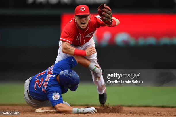 Scooter Gennett of the Cincinnati Reds completes a double play in the seventh inning as Kyle Schwarber of the Chicago Cubs slides in to second base...