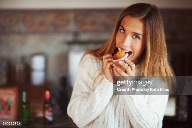 pretty woman eating muffin - avarice fotografías e imágenes de stock