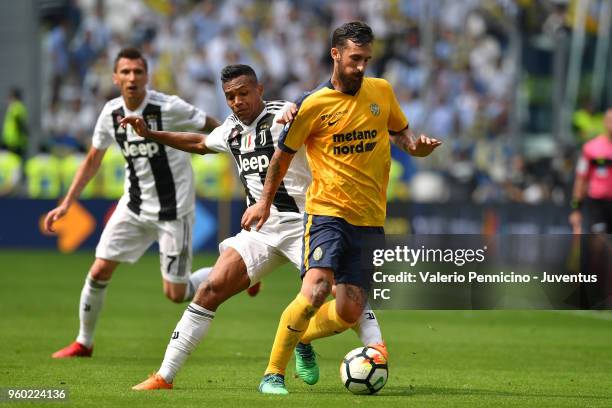 Alex Sandro of Juventus competes for the ball with Antonio Caracciolo of Hellas Verona FC during the serie A match between Juventus and Hellas Verona...