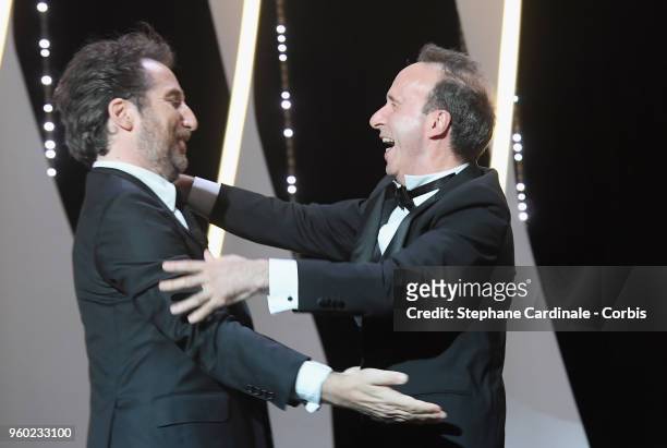 Master of Ceremonies Edouard Baer hugs Roberto Begnini on stage during the Closing Ceremony at the 71st annual Cannes Film Festival at Palais des...