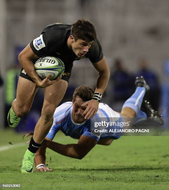 Argentina's Jaguares wing Bautista Delguy eludes South Africa's Bulls centre JT Jackson during their Super Rugby match at Jose Amalfitani stadium in...