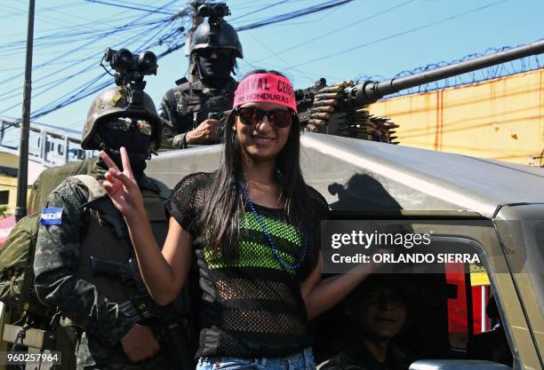 Reveler climbs onto a military truck parading during the International Carnival of Friendship in La Ceiba, Honduran Caribbean, on May 19, 2018.