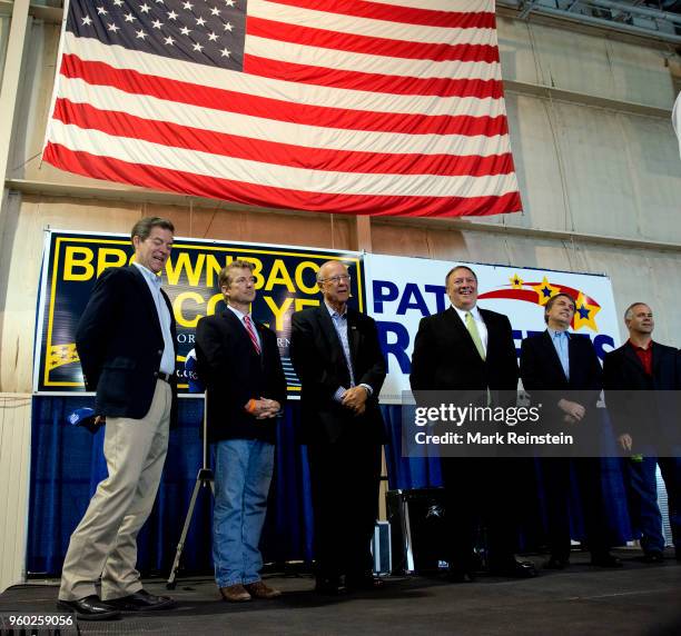 View of American politicians, all Republican party members from Kansas, as they pose together on stage during a rally in support of reelection...