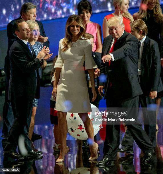 View of former model Melania Trump and real estate developer & presidential candidate Donald Trump hold hands as the latter points from the stage at...