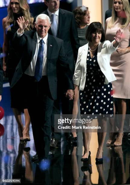 Indiana Governor and US vice-presidential candidate Mike Pence and his wife Karen hold hands as they wave from the stage at the close of the...