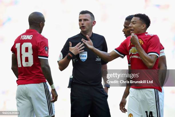 Referee Michael Oliver talks with Ashley Young and Jesse Lingard both of Manchester United during the Emirates FA Cup Final between Chelsea and...