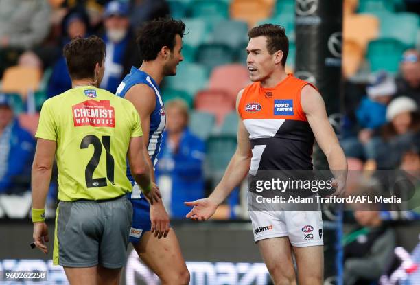 Robbie Tarrant of the Kangaroos gets stuck into Jeremy Cameron of the Giants after Cameron had a Giants shot on goal overturned for his bump on Jamie...