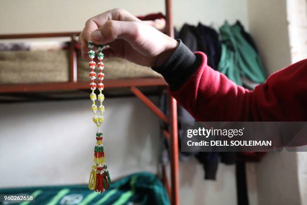 An adolescent boy shows prayer beads he made at the "Hori" rehabilitation centre for former Islamic State group child fighters run by Kurds in Tal...