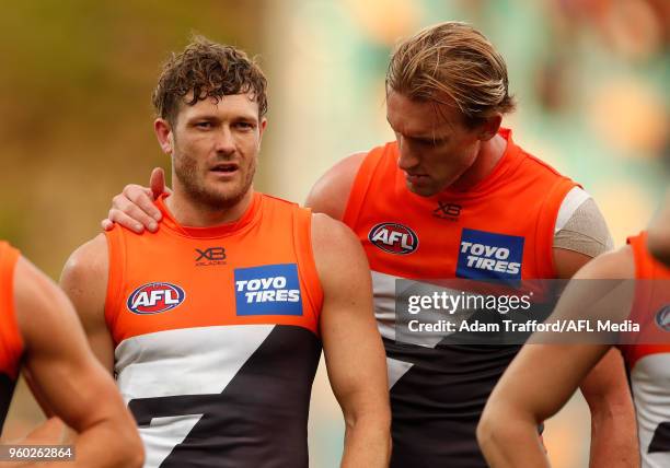 Lachlan Keeffe of the Giants checks on an injured Sam Reid of the Giants during the 2018 AFL round nine match between the North Melbourne Kangaroos...