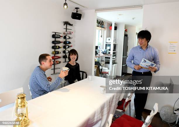 This May 12, 2018 picture shows room rental user Max Ikeda, a Ukrainian-Japanese living in Hiroshima , talking with rental house owner Nobuhide...