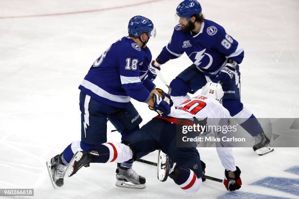 Brett Connolly of the Washington Capitals falls to the ice against Ondrej Palat and Nikita Kucherov of the Tampa Bay Lightning during the third...