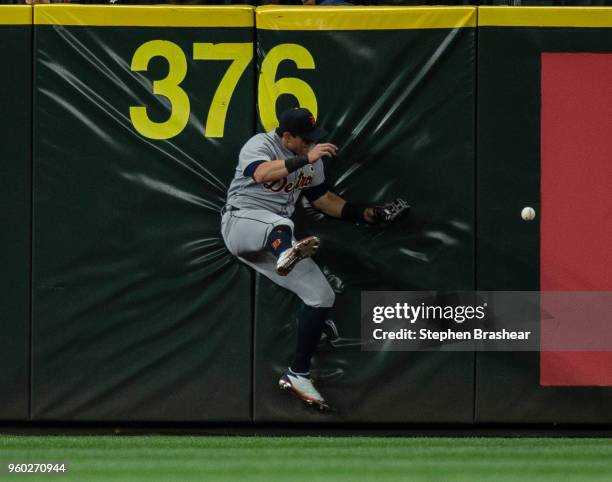 Leftfielder Mikie Mahtook of the Detroit Tigers hits the outfield wall after he cannot get to a ball hit by Guillermo Heredia of the Seattle Mariners...