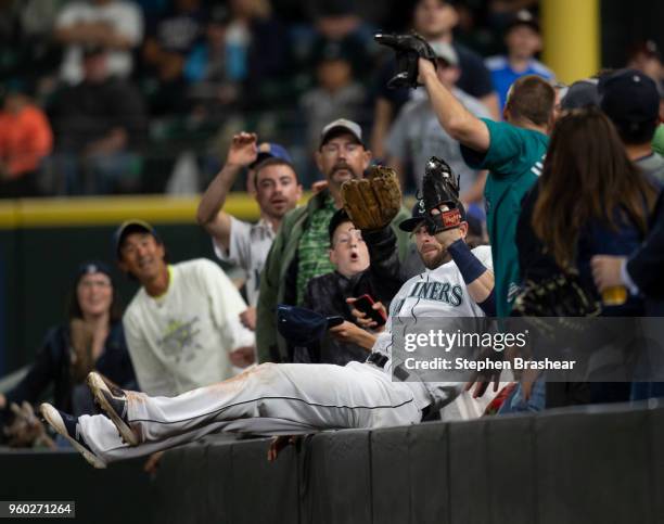 Rightfielder Mitch Haniger of the Seattle Mariners falls into the stands after catching a ball hit by Jose Iglesias of the Detroit Tigers during the...