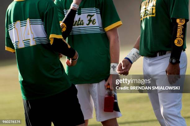 Tributes to shooting victims are seen on team members before a Santa Fe High School baseball makeup game a day after the mass shooting May 19, 2018...