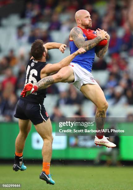 Nathan Jones of the Demons marks the ball over Matthew Wright of the Blues during the round nine AFL match between the Carlton Blues and the...