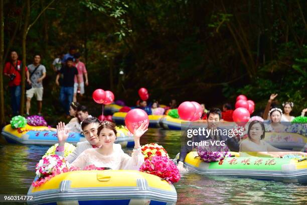 Staff members of Gulong Canyon Ecological Tourist Area with their mates participate in a group wedding at Gulong Canyon on May 19, 2018 in Qingyuan,...