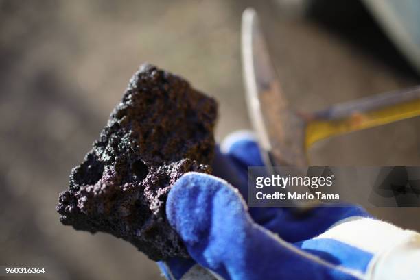 Geologist holds a collected lava rock to be analyzed from a recent Lava flow from a Kilauea volcano fissure on Hawaii's Big Island on May 19, 2018 in...