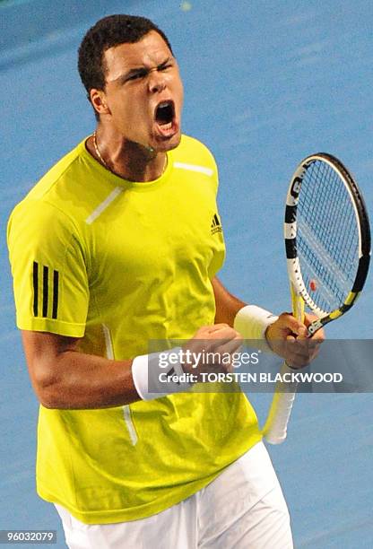 French tennis player Jo Wilfried Tsonga celebrates winning a point during his third round men's singles match against German opponent Tommy Haas at...