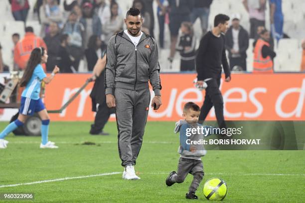 Olympique de Marseille's French forward Dimitri Payet plays football with a child at the end of the French L1 football match Olympique of Marseille...