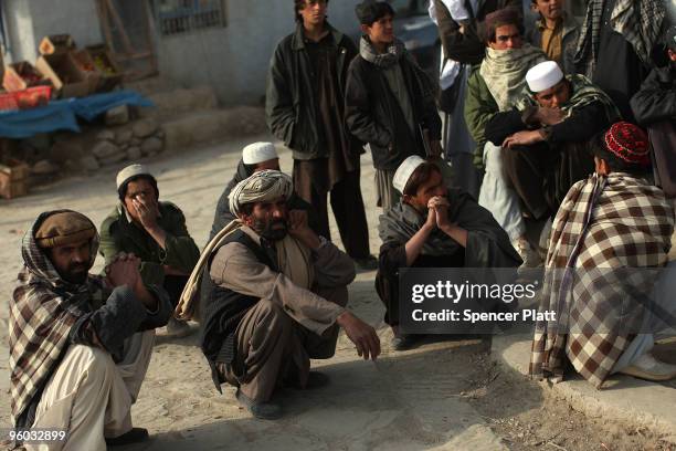 Villagers watch members of the US Army Able Company, 3-509 Infantry Battalion patrol the main street of Zerak January 23, 2010 next to their Combat...