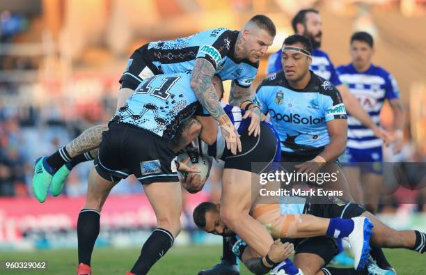 David Klemmer of the Bulldogs is tackled by josh Dugan and Kurt Capewell of the Sharks during the round 11 NRL match between the Cronulla Sharks and...