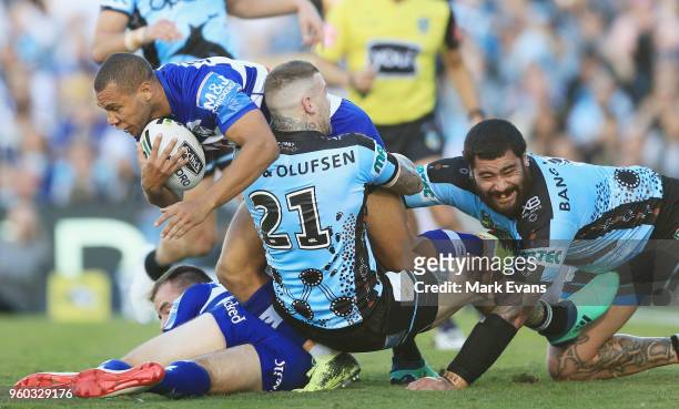 Moses Mbye of the Bulldogs is tackled by Josh Dugan and Andrew Fifita of the Sharks during the round 11 NRL match between the Cronulla Sharks and the...