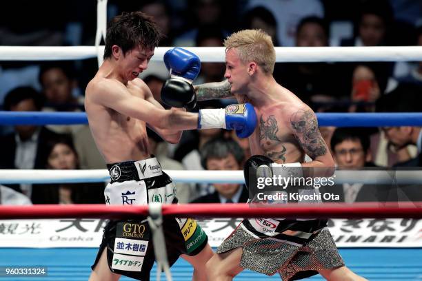 Challenger Hekkie Budler of South Africa punches champion Ryoichi Taguchi of Japan during the IBF & WBA Light Flyweight Title Bout at Ota City...