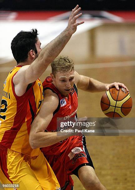 Shawn Redhage of the Wildcats drives past Sam Mackinnon of the Tigers during the round 17 NBL match between the Perth Wildcats and the Melbourne...