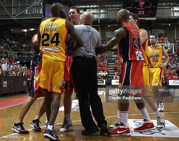 The referee separates Julius Hodge of the Tigers and Galen Young of the Wildcats during the round 17 NBL match between the Perth Wildcats and the...