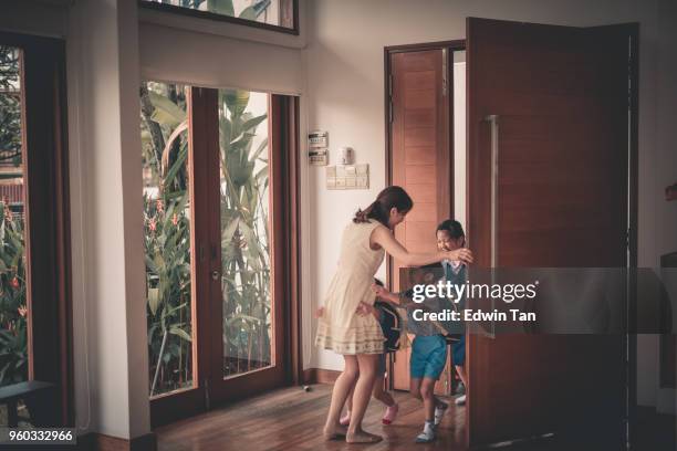 aziatische chinese familie kinderen komt terug van school - arriving home stockfoto's en -beelden