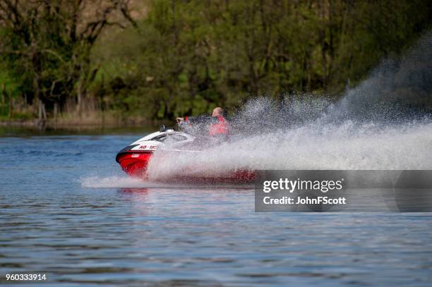 man on a jet ski on a scottish loch - johnfscott stock pictures, royalty-free photos & images