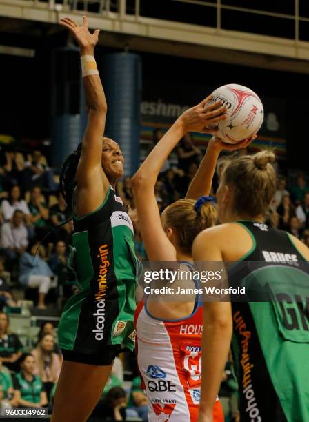Stacey Francis of the West Coast Fever jumps up high to defend Helen Housby of the NSW Swifts shot on goal during the round four Super Netball match...
