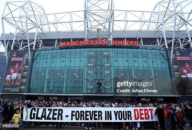 Manchester United fans, wearing green and gold scarves, protest against the Glazers, current owners of Manchester United before the Barclays Premier...