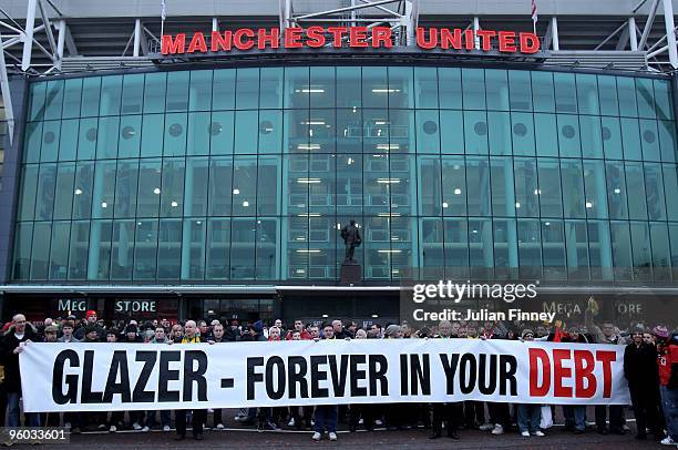 Manchester United fans, wearing green and gold scarves, protest against the Glazers, current owners of Manchester United before the Barclays Premier...