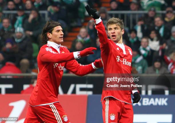 Thomas Mueller of Muenchen celebrates with his team mate Mario Gomez after scoring his team's first goal during the Bundesliga match between Werder...