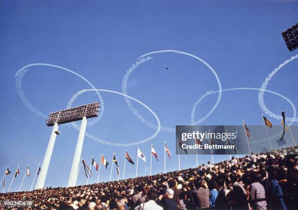 Sky writers trace the Olympic symbols, interlocking rings, in the air above the National stadium on Opening day.