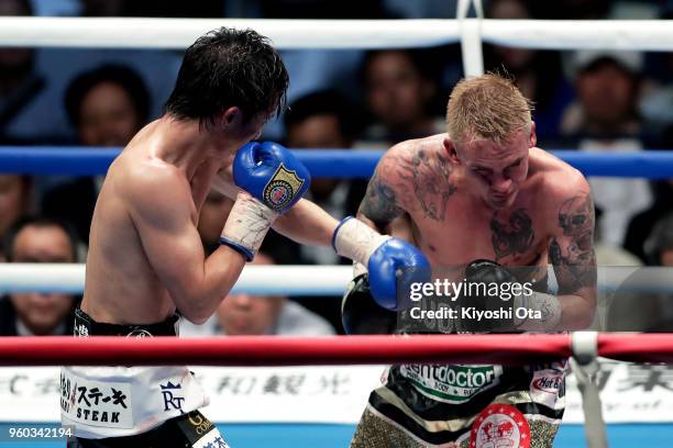 Champion Ryoichi Taguchi of Japan punches challenger Hekkie Budler of South Africa during the IBF & WBA Light Flyweight Title Bout at Ota City...