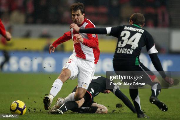 Andreas Ivanschitz of Mainz is challenged by Jan Rosenthal and Konstantin Rausch of Hannover during the Bundesliga match between FSV Mainz 05 and...