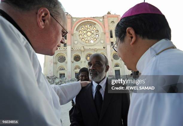 Haitian President Rene Preval is greeted by US Archbishop Timothy Dolan before the funeral of Haitian Archbishopo Joseph Serge Miot killed in last...