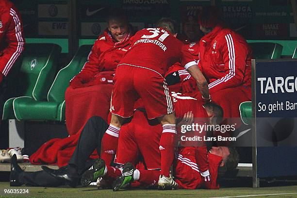 Arjen Robben of Muenchen celebrates with head coach Louis van Gaal after scoring his teams third goal during the Bundesliga match between SV Werder...