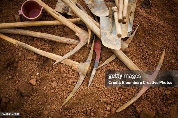 tools of daily wage laborers are piled on the ground while they take a break from work - pickaxe bildbanksfoton och bilder