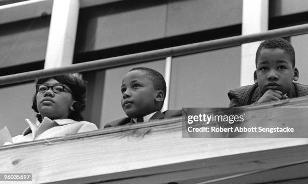 Yolanda King, Martin Luther King III, and Dexter Scott King, children of Coretta Scott and Martin Luther King, Jr., listen to speeches during a rally...