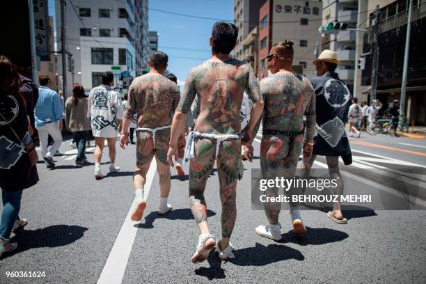 Participants with traditional Japanese tattoos , related to the Yakuza, walk through the Asakusa district during the annual Sanja Matsuri festival in...