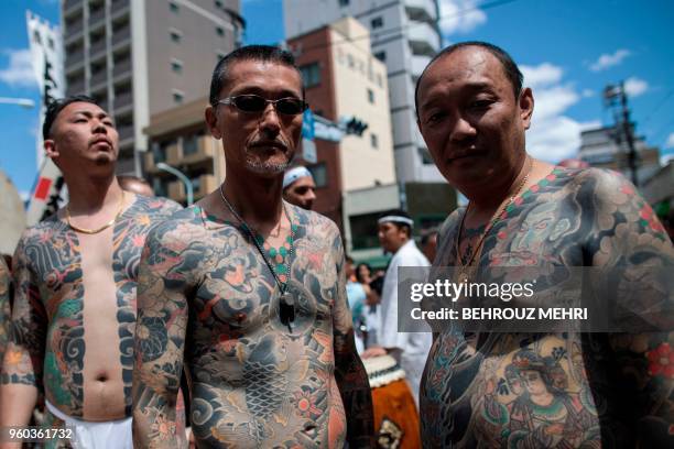 Participants pose to show their traditional Japanese tattoos , related to the Yakuza, during the annual Sanja Matsuri festival in the Asakusa...