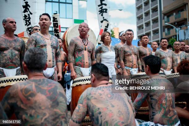 Participants pose to show their traditional Japanese tattoos , related to the Yakuza, during the annual Sanja Matsuri festival in the Asakusa...