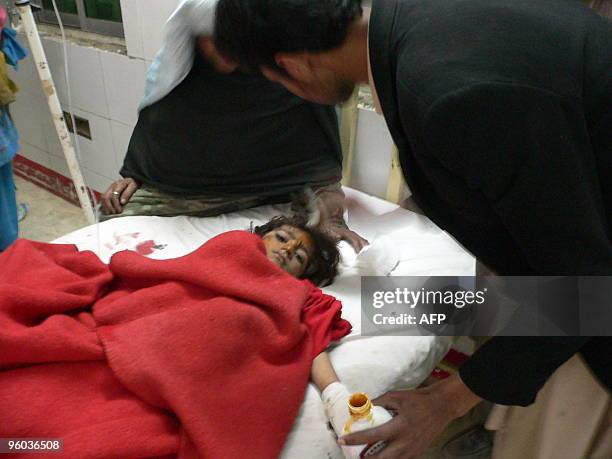 Pakistani paramedic staff member gives treatment to an injured girl at a hospital after a suicide car bomb attack in Dera Ismail Khan on January 23,...