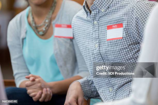 onherkenbaar volwassenen met naamlabels tijdens vergadering - naamplaatje etiket stockfoto's en -beelden