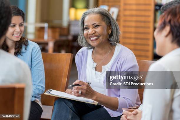 senior female mental health professional facilitates group therapy session - inclusive classroom stock pictures, royalty-free photos & images