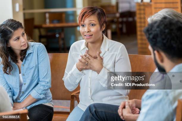 vulnerable woman discusses something in support group - vulnerability stock pictures, royalty-free photos & images