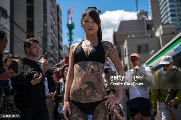 Heavily tattooed Japanese woman poses for photographs near Asakusa Temple during the third and final day of Sanja Festival, on May 20, 2018 in Tokyo,...